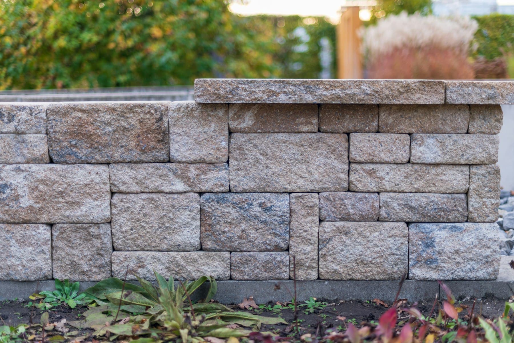 Finished segmental block retaining wall with capstones in warm evening light